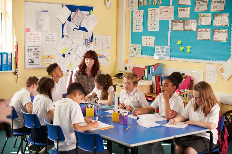 A female teacher with here students in the classroom