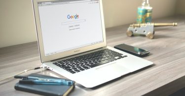 A computer standing on Desk, Displaying Google Main page.