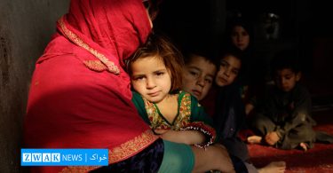 An Afghan mother holds her baby daughter in her arms.