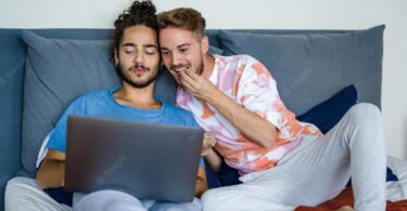 young couple same sex people having breakfast bed gay couple men watching movie laptop video call lockdown quarantine due covid19 epidemic 164678 365