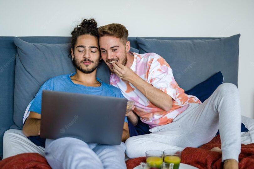 young couple same sex people having breakfast bed gay couple men watching movie laptop video call lockdown quarantine due covid19 epidemic 164678 365